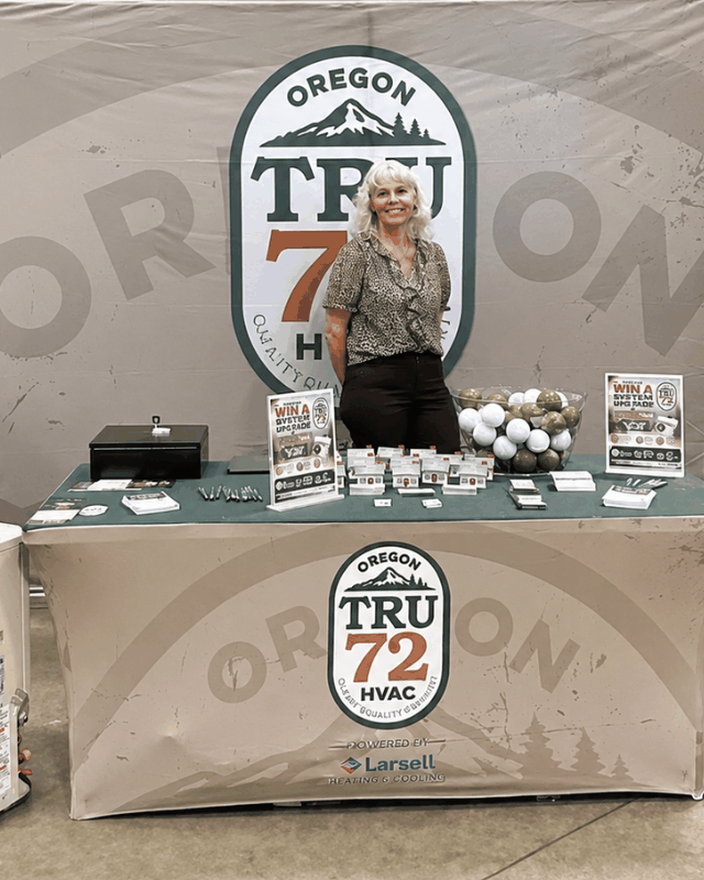 Kim Smyth, general manager of the Tru72 Albany office, standing at the Tru72 stand in front of an Oregon Tru72 HVAC banner.